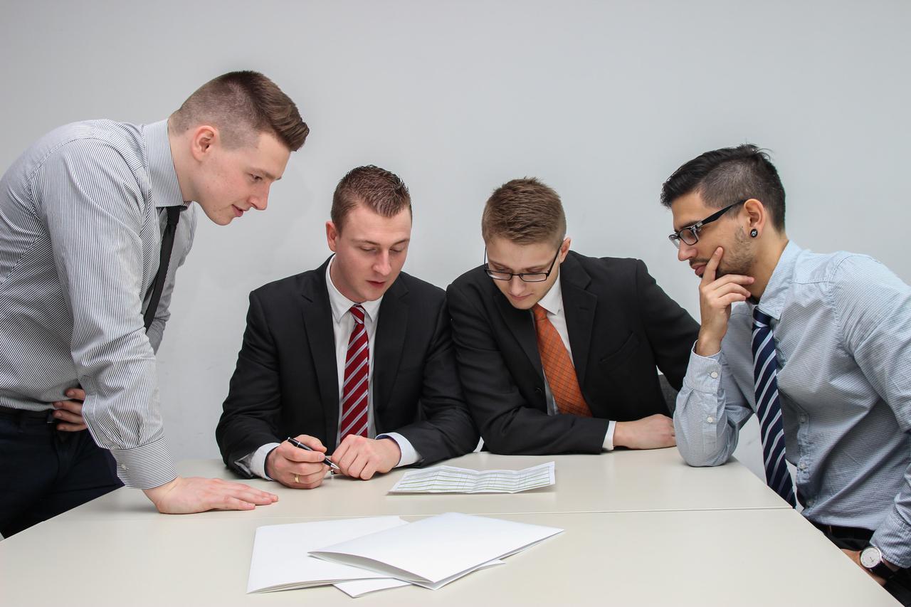 A group of lawyers in suits and ties analyzing a document and discussing it. A Tampa, FL criminal defense attorney is your surest route to redemption.