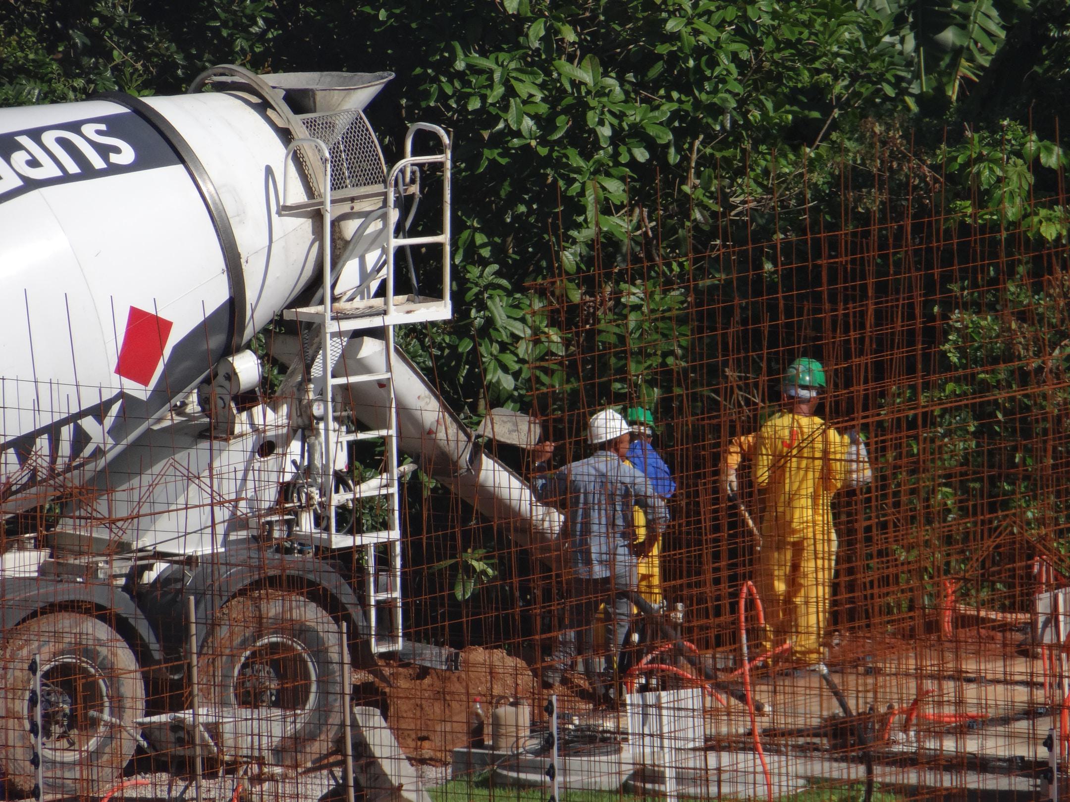 Concrete workers pouring concrete into a construction site.
