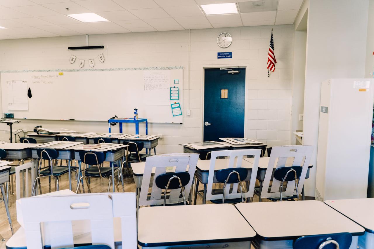 Bright empty classroom featuring desks, a whiteboard. Ideal learning environment.
