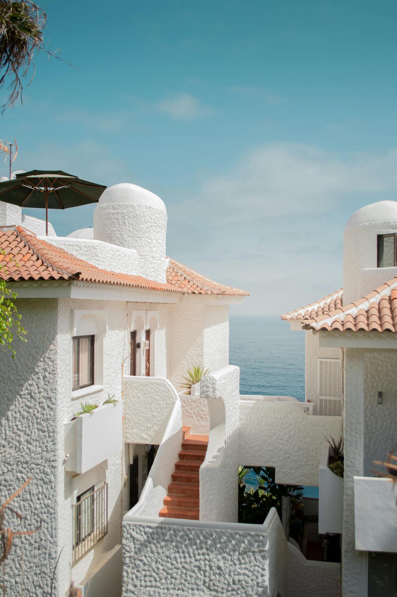 Elegant white Mediterranean-style houses with sea view and blue skies, perfect for coastal living.