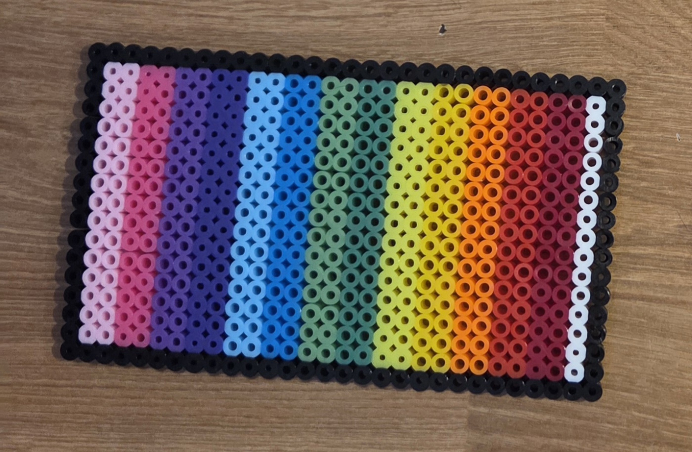 Vibrant colorful perler bead art piece with rainbow colors