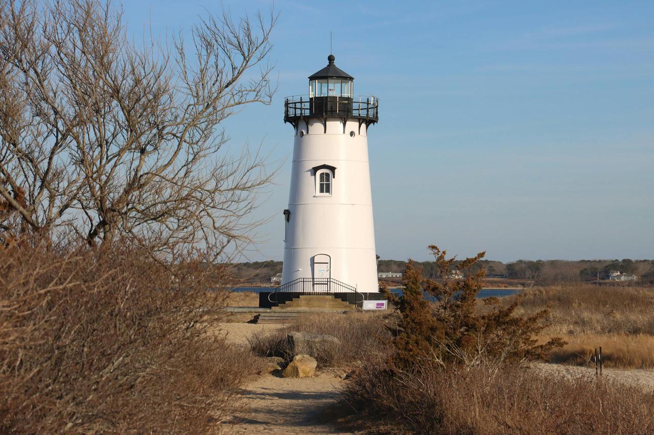 Scenic view of Edgartown Lighthouse surrounded by nature, captured on a sunny day.