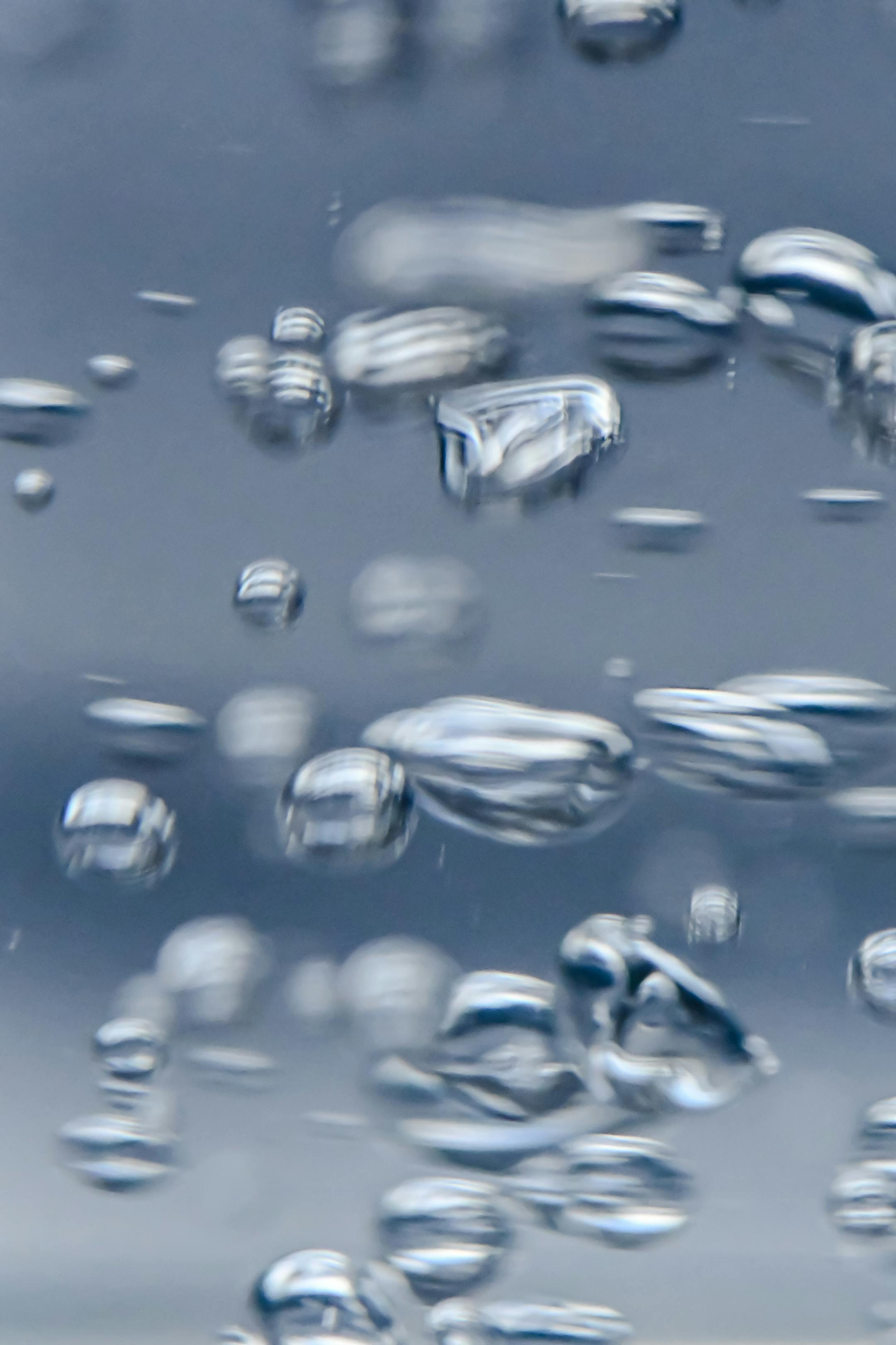 Detailed close-up of water bubbles moving in a clear liquid. Perfect for abstract backgrounds.