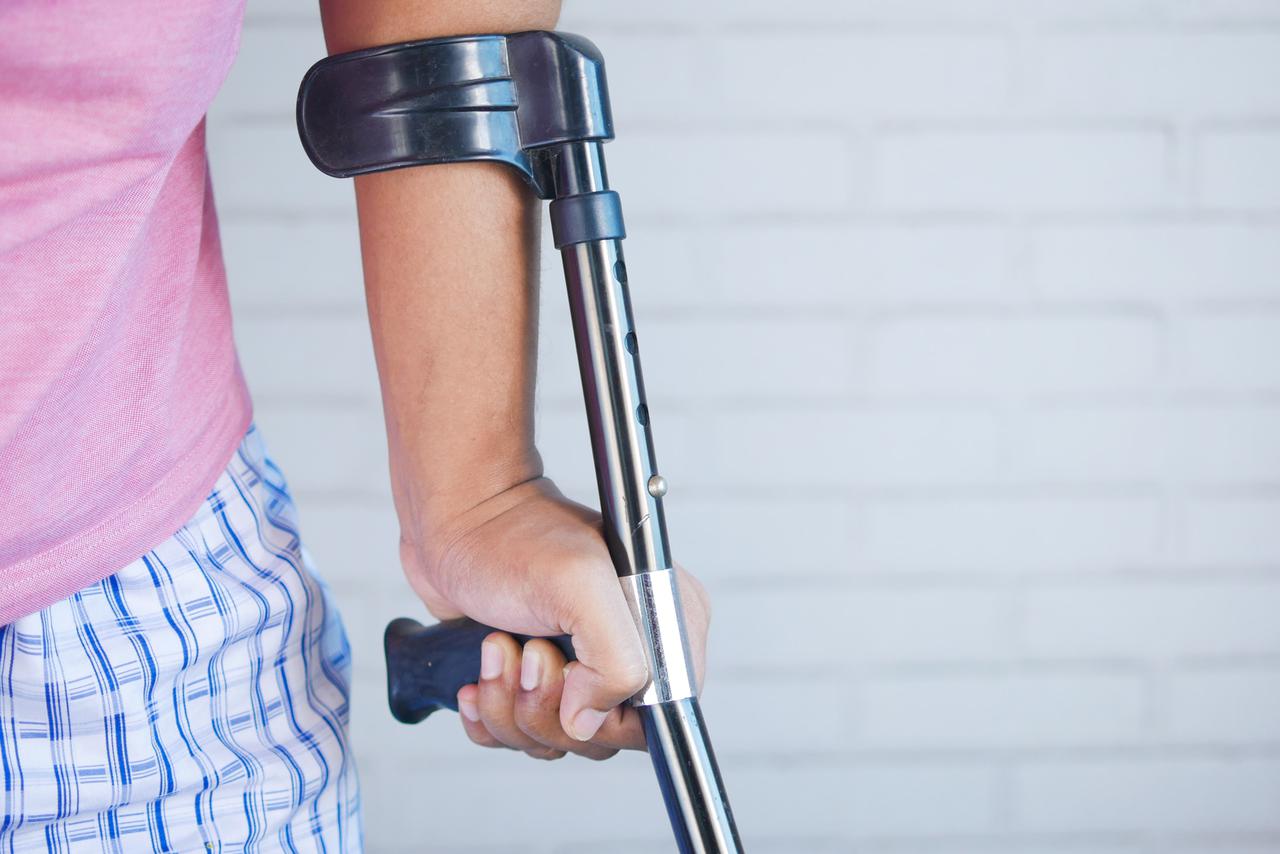 Injured person using a crutch.