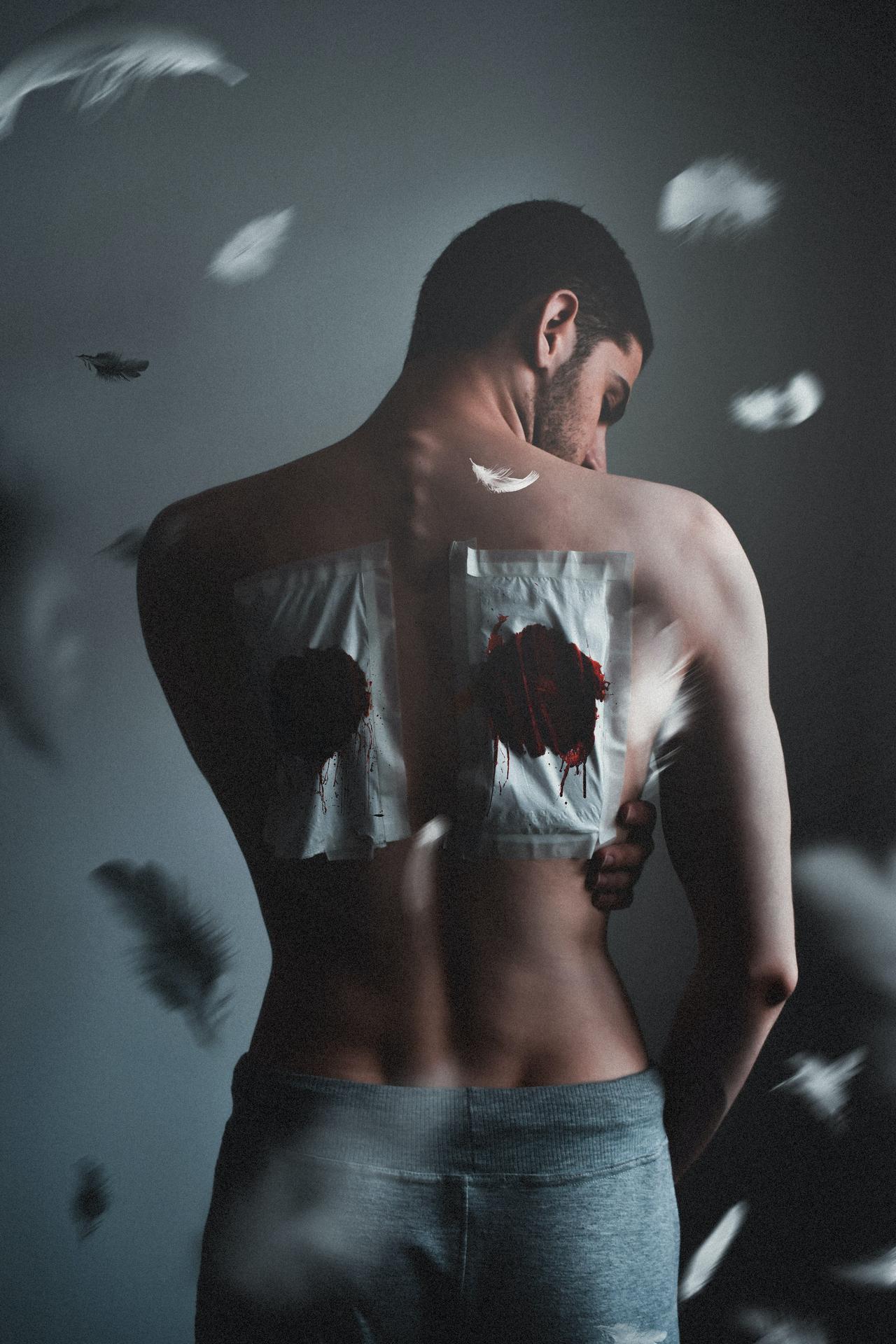 A man with bloodied bandages on his back.