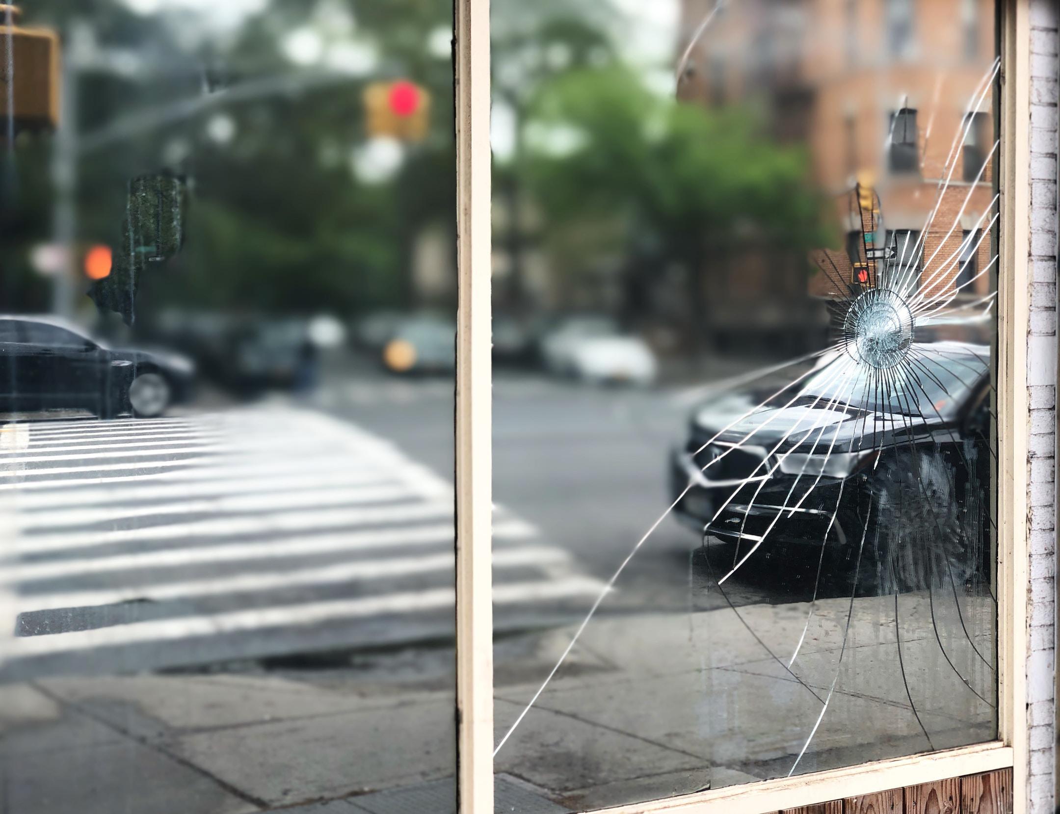 A car as seen through a smashed point in a window.