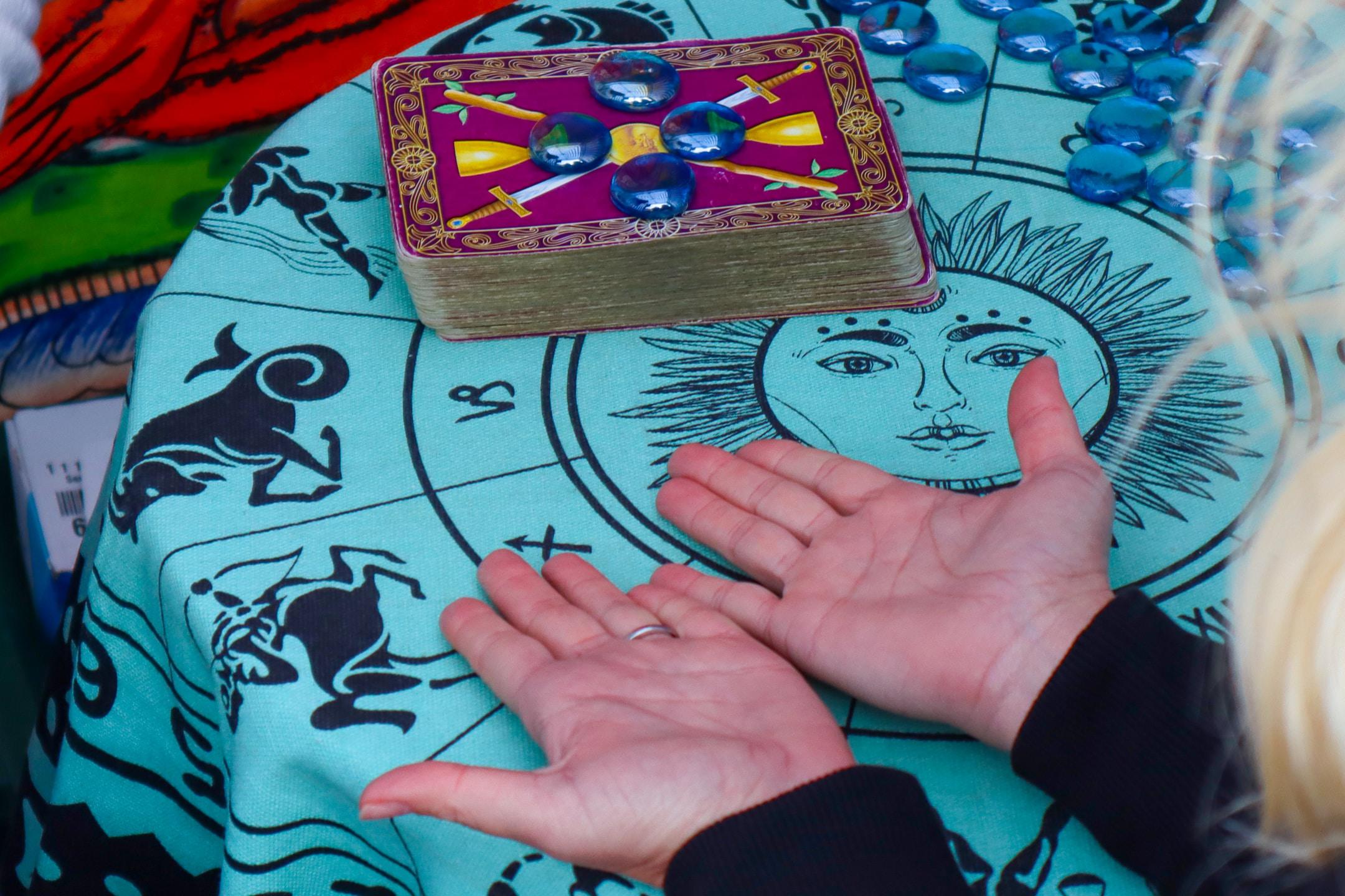A psychic advisor in Sacramento reading palms and tarot cards.