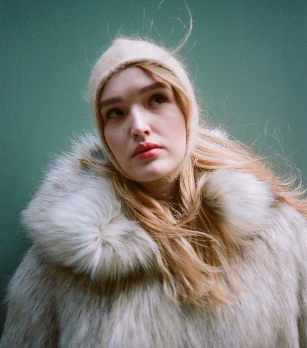 Editorial portrait supplied by Jessica Wright: blonde hair in motion, a fur coat and a knit hood