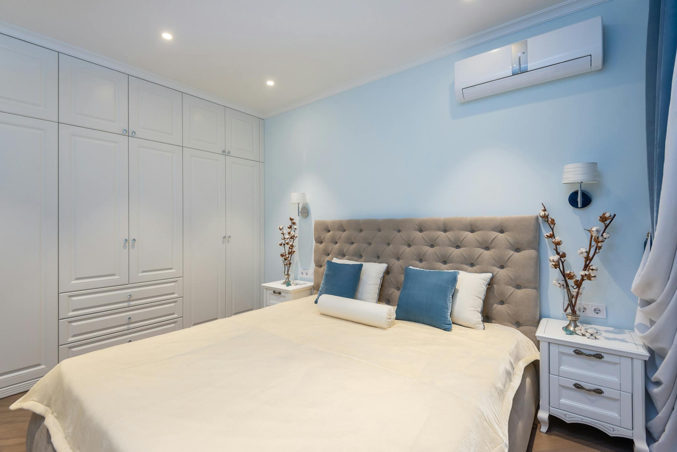 A beautifully designed bedroom with elegant decor, blue accents, and cozy furnishings.