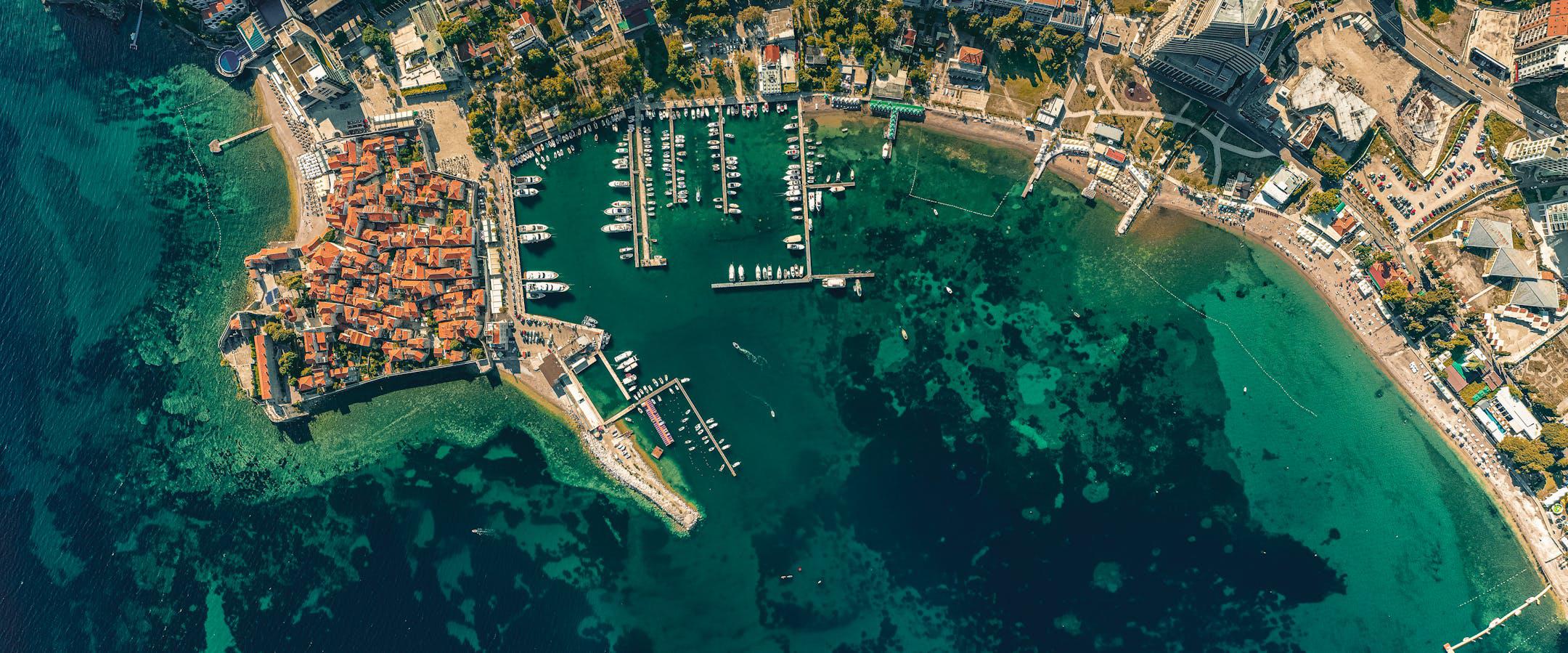 A stunning aerial shot of Budva's coastal cityscape and harbor in Montenegro.
