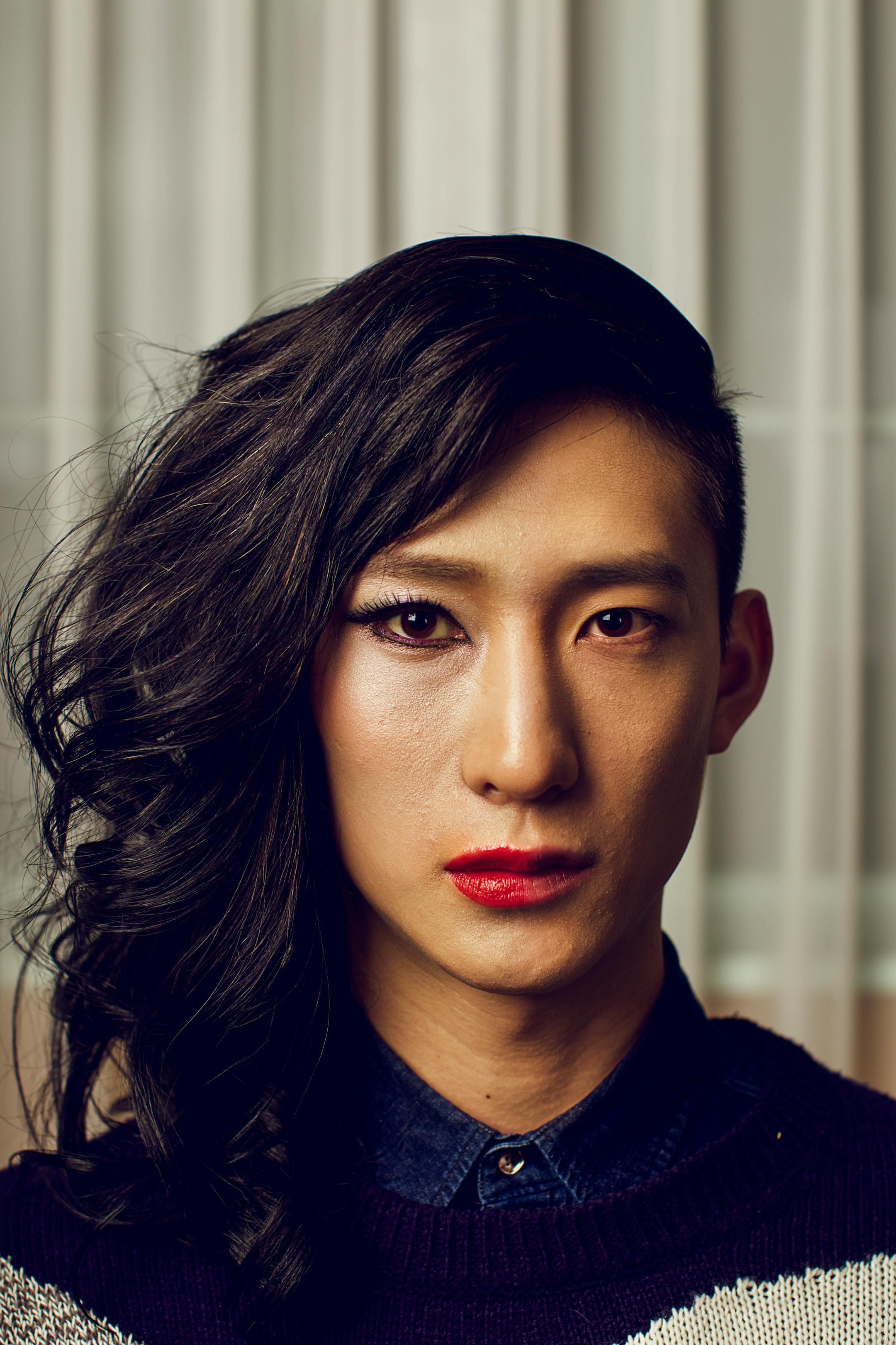 Androgynous model showcasing bold makeup and unique hairstyle.