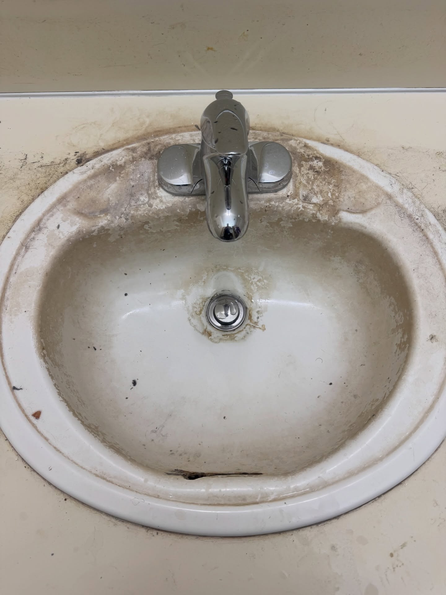 Bathroom sink with water stains and buildup before professional deep clean