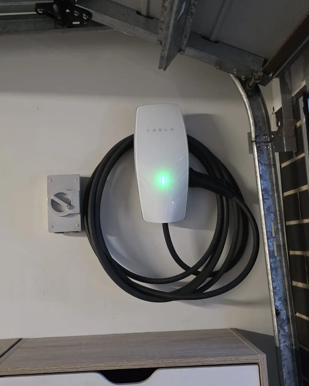 Tesla Wall Connector with isolator switch installed on a garage wall in Aintree