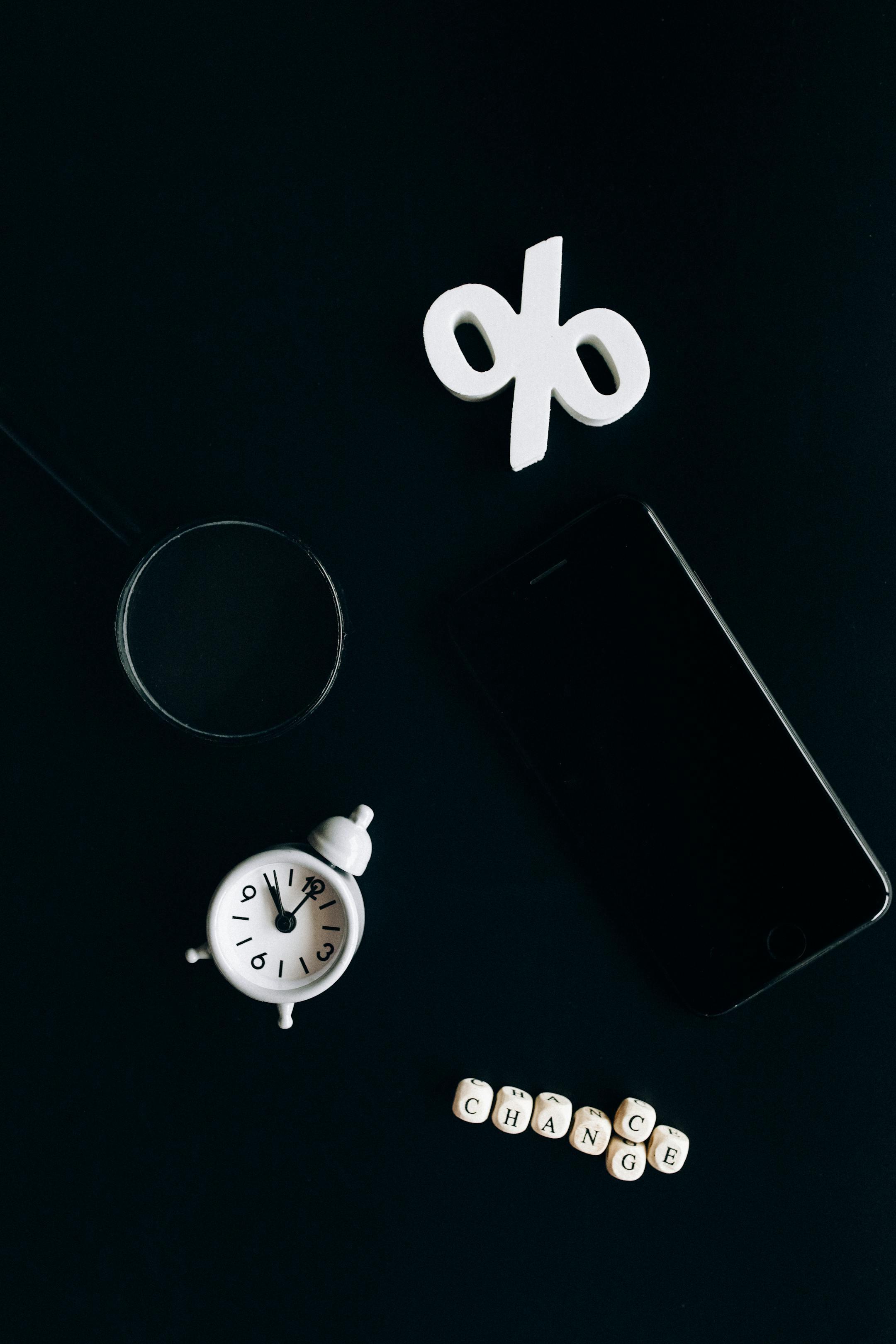 Stylish composition of clock, symbols, and text representing financial change on a dark background.