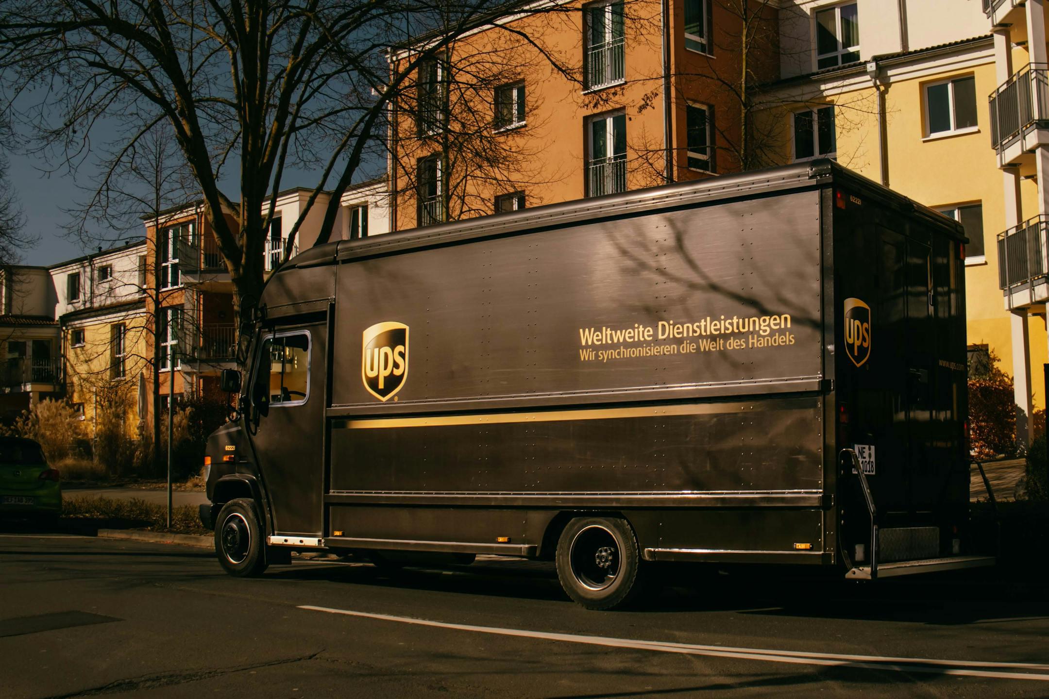 UPS delivery truck parked on a sunny street in a residential neighborhood.