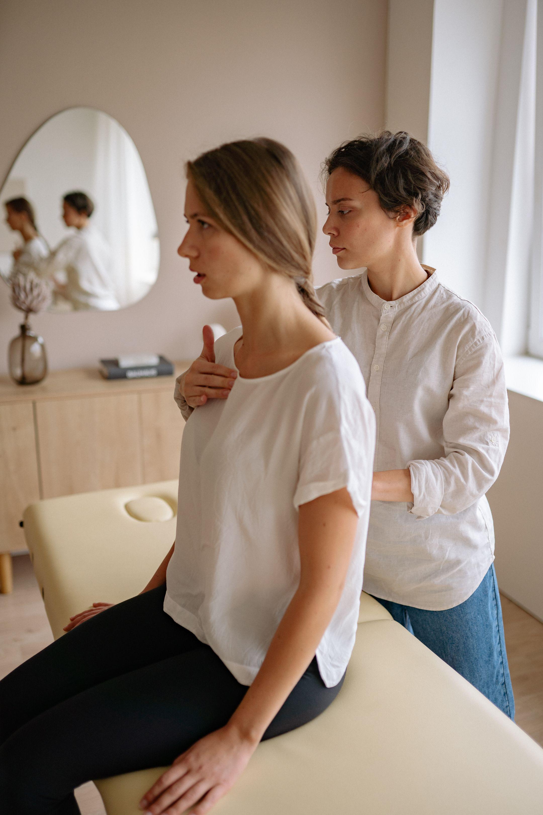 Two women engaging in a therapeutic physical therapy session in a serene indoor setting.