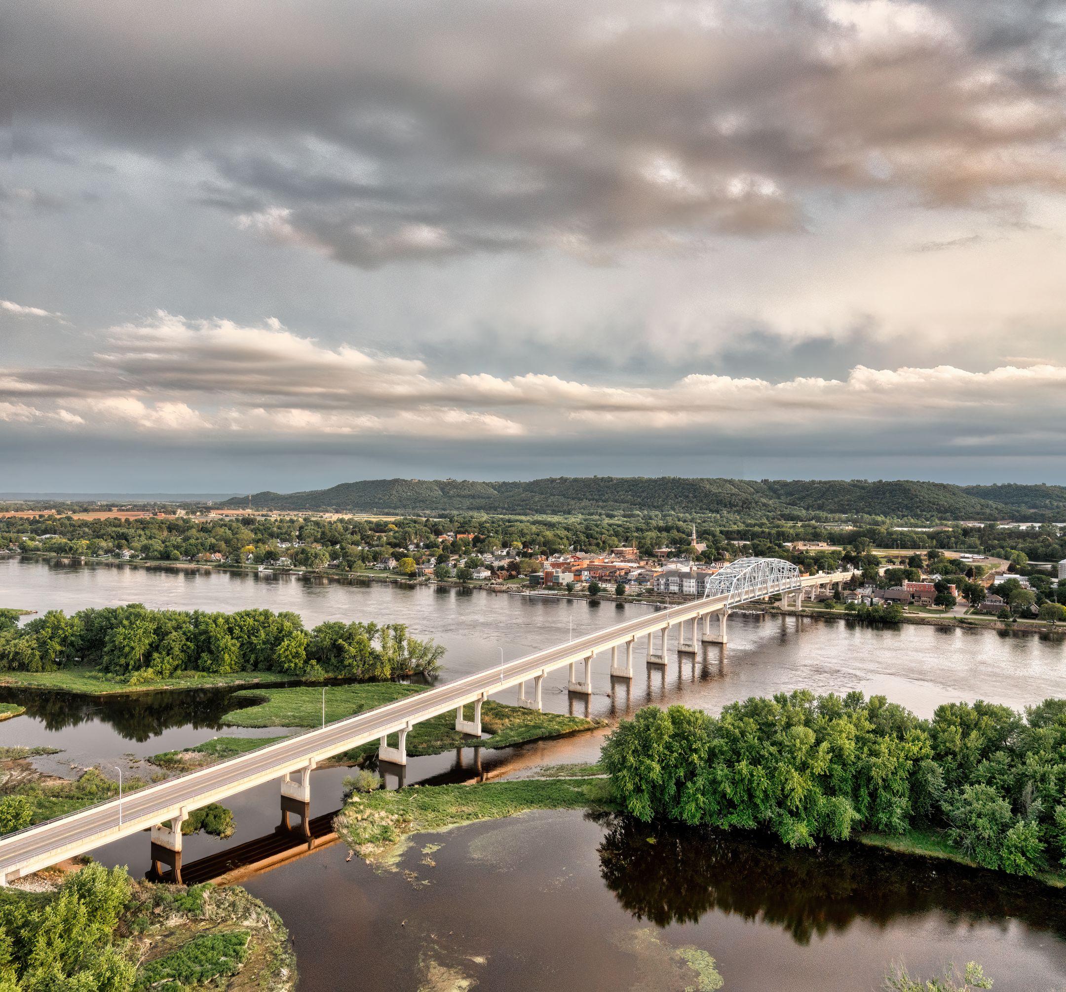 Aerial view of the Wabasha Bridge spanning the Mississippi River amidst lush greenery and cityscape.