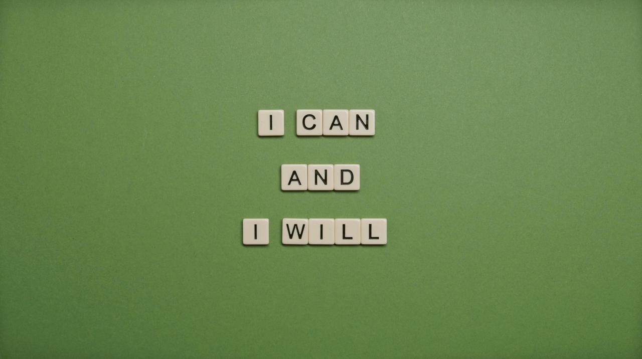 Inspirational message 'I Can and I Will' spelled with tile letters on a green background.