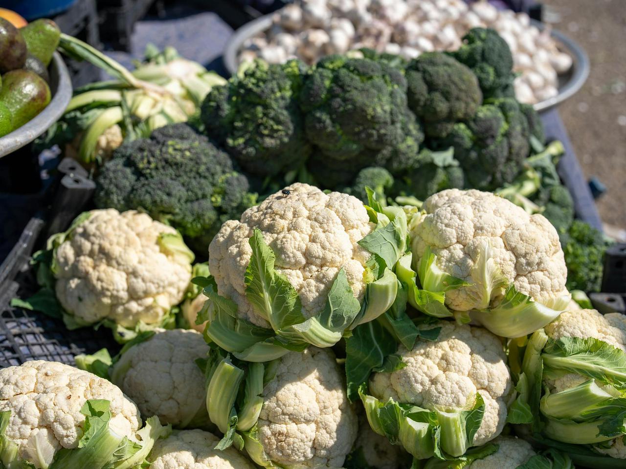 Fresh cauliflower and broccoli displayed at a bustling market in Kahramanmaraş, Türkiye.