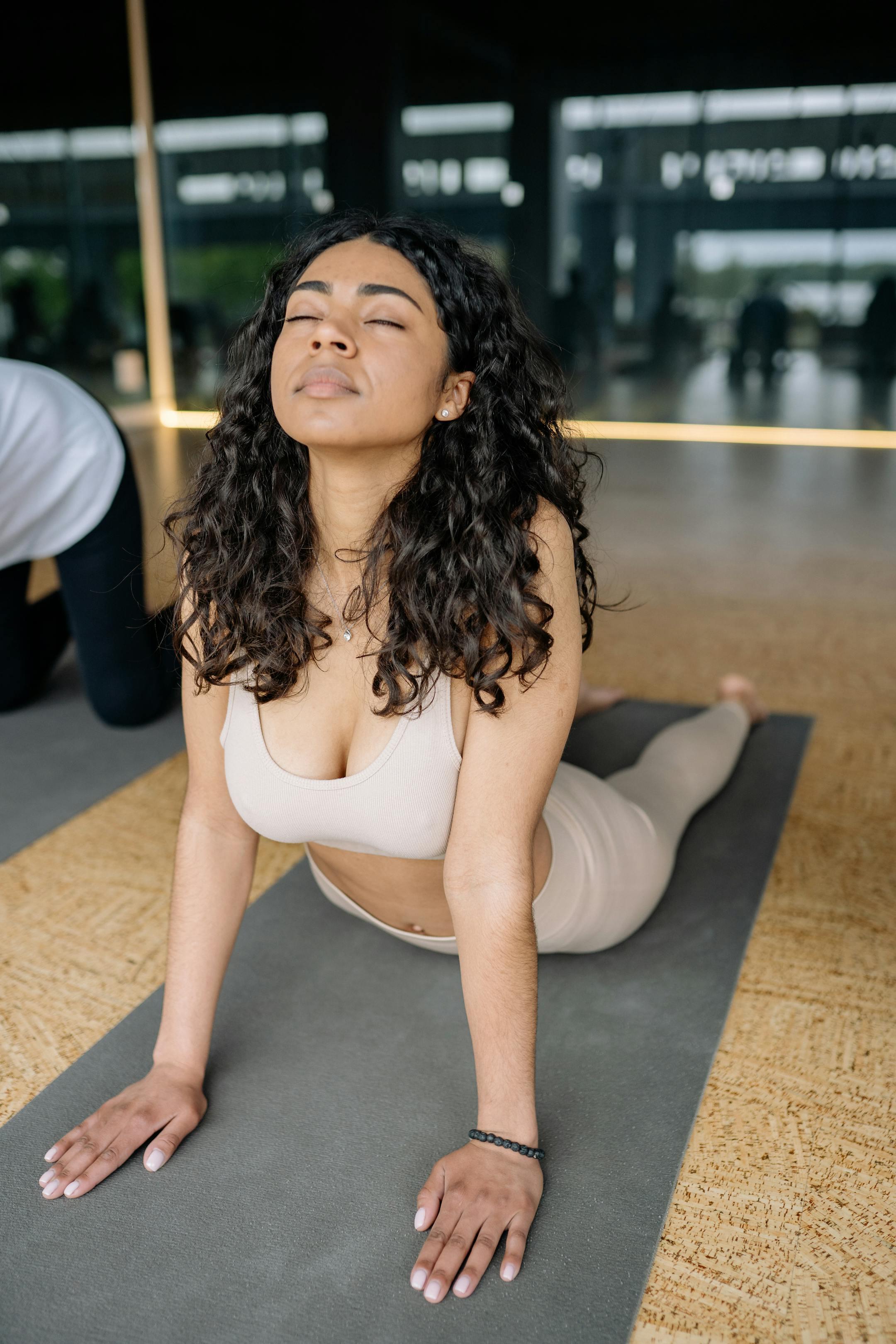 A young woman practicing yoga in a bright studio, focusing on stretching and relaxation.