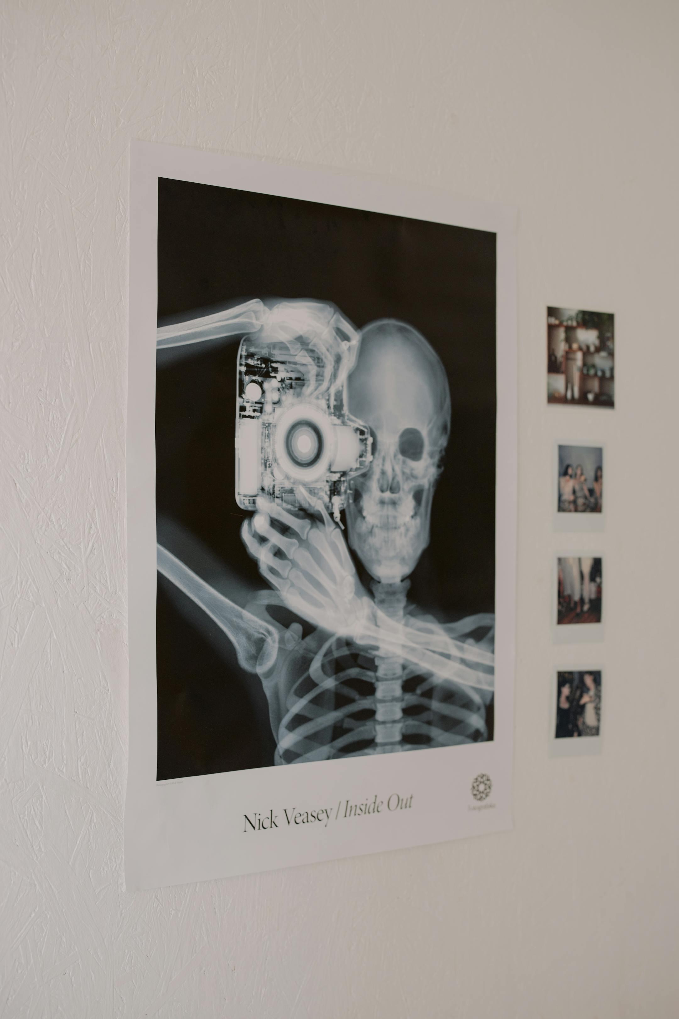 A stylish X-ray art poster featuring a skeleton with a camera, adding an artistic touch to a minimalist interior.