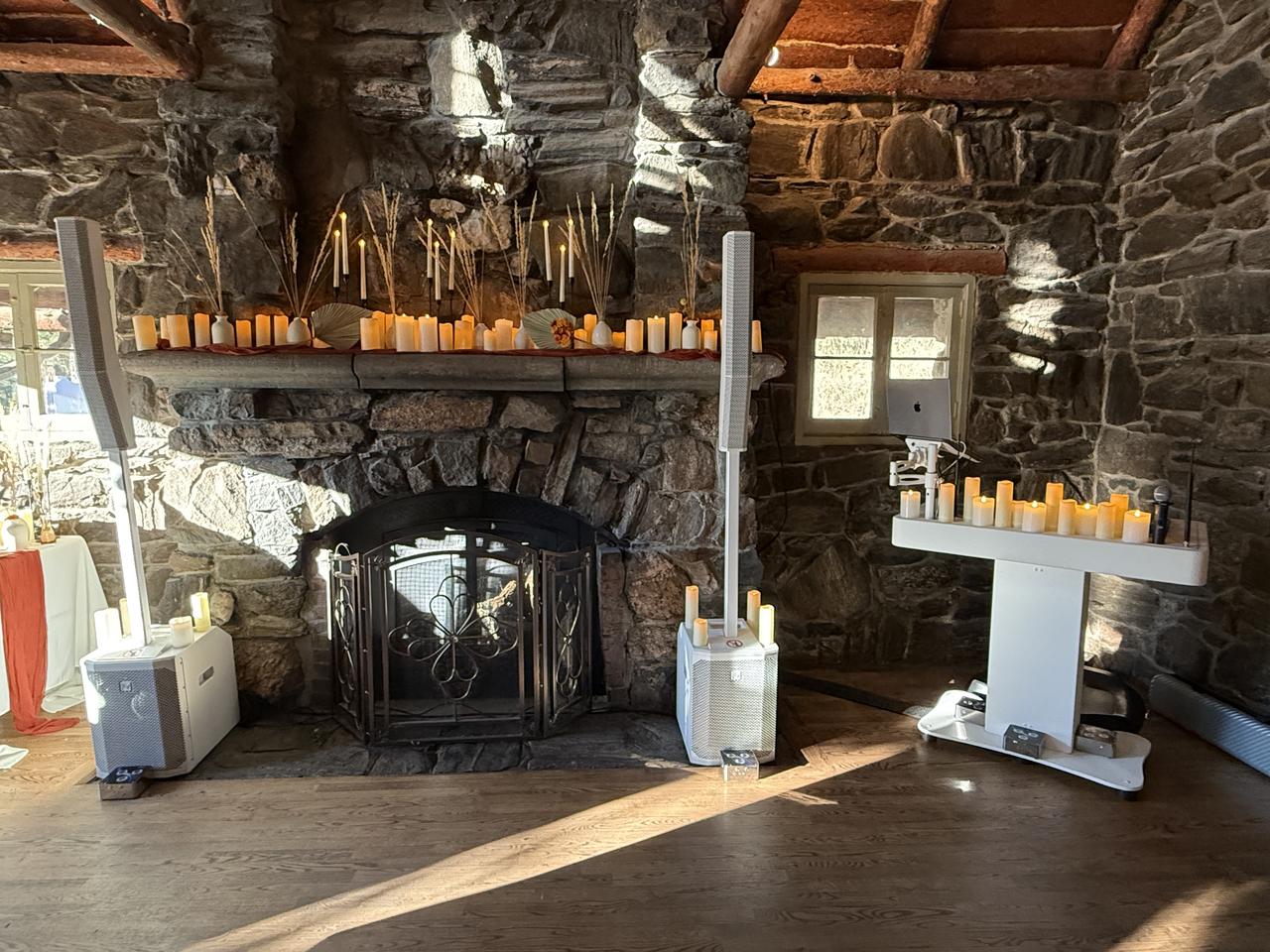 Rustic wedding reception setup by Full House Entertainment DJ and lighting team in Salida, Colorado — elegant indoor venue with stone fireplace and candlelit décor.
