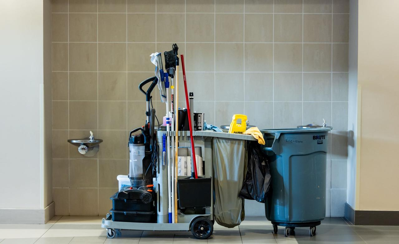A comprehensive collection of professional cleaning tools on a cart in an indoor environment.