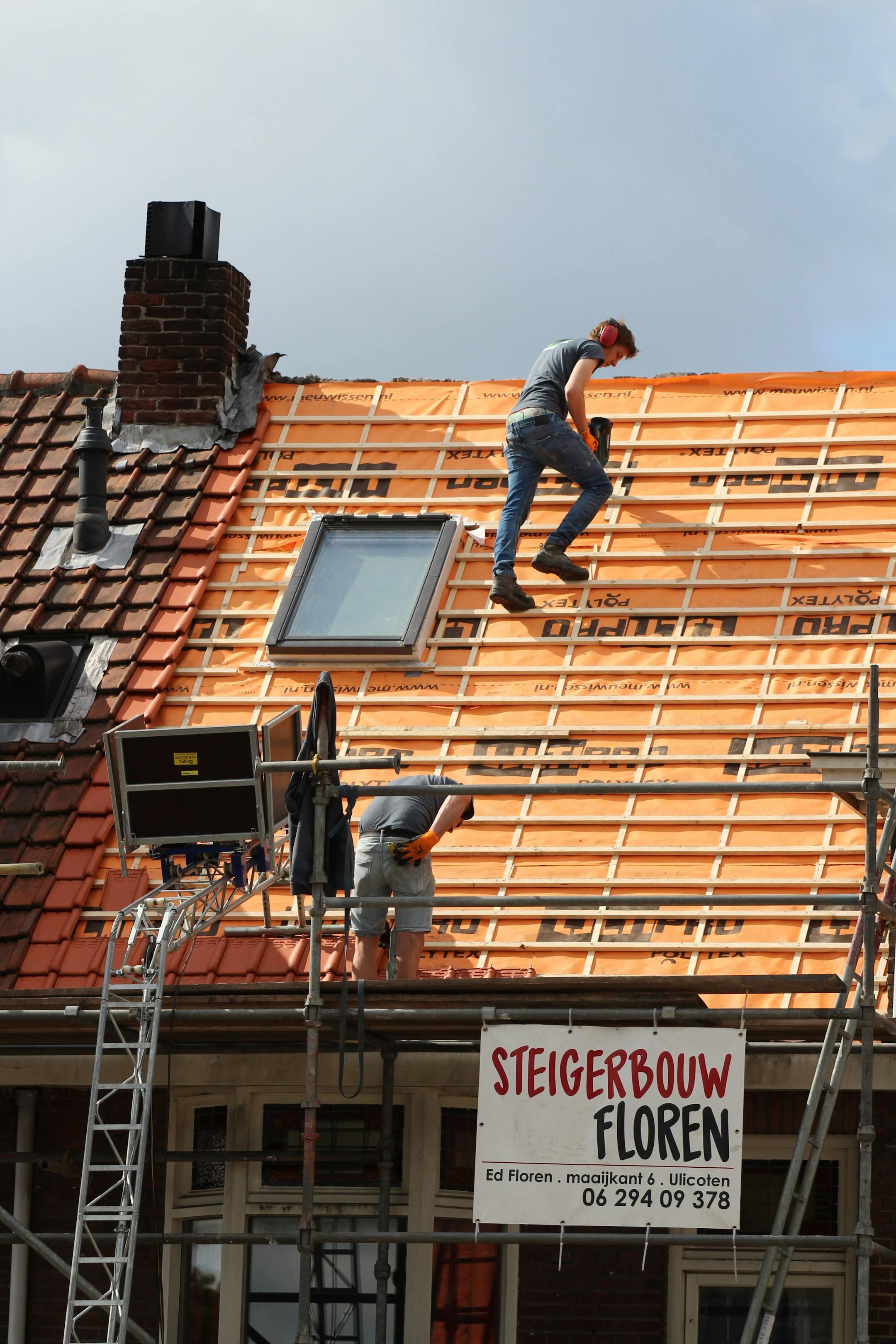 Construction workers installing new roof tiles in the Netherlands.