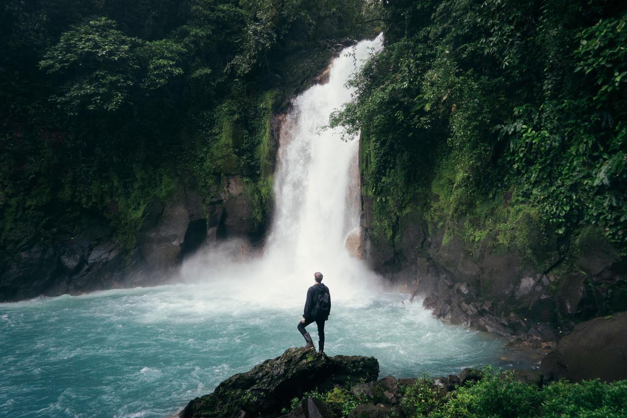 a hiker observing a waterfall