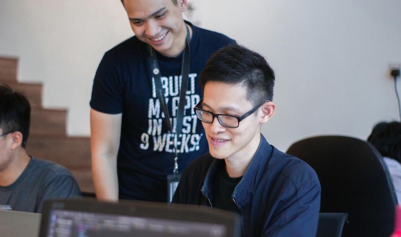 A mentor guiding a coding student 