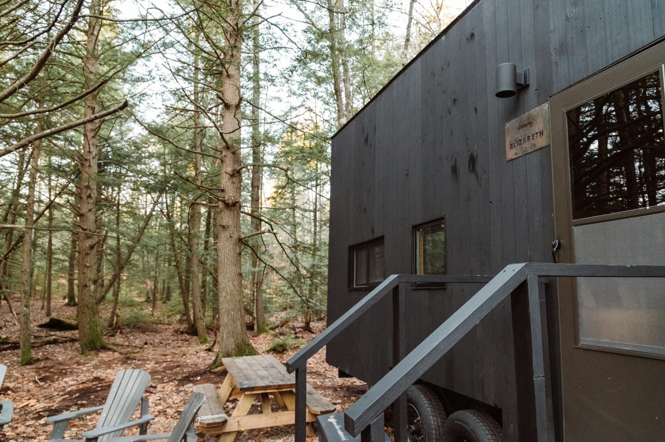 Explore a secluded tiny home in Epsom's lush autumn woods, perfect for a peaceful getaway.