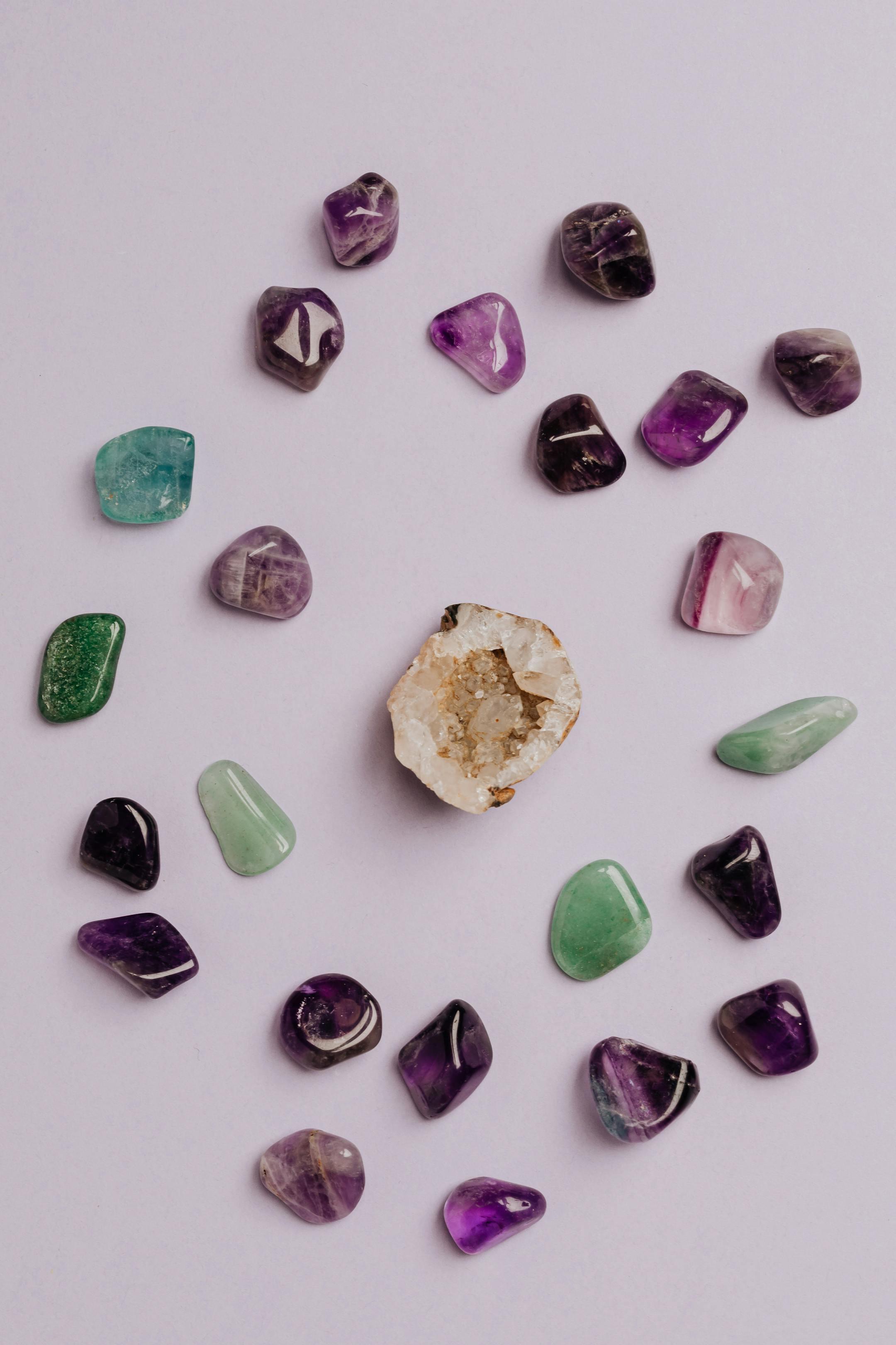 A collection of colorful tumbled gemstones artfully arranged on a neutral background.