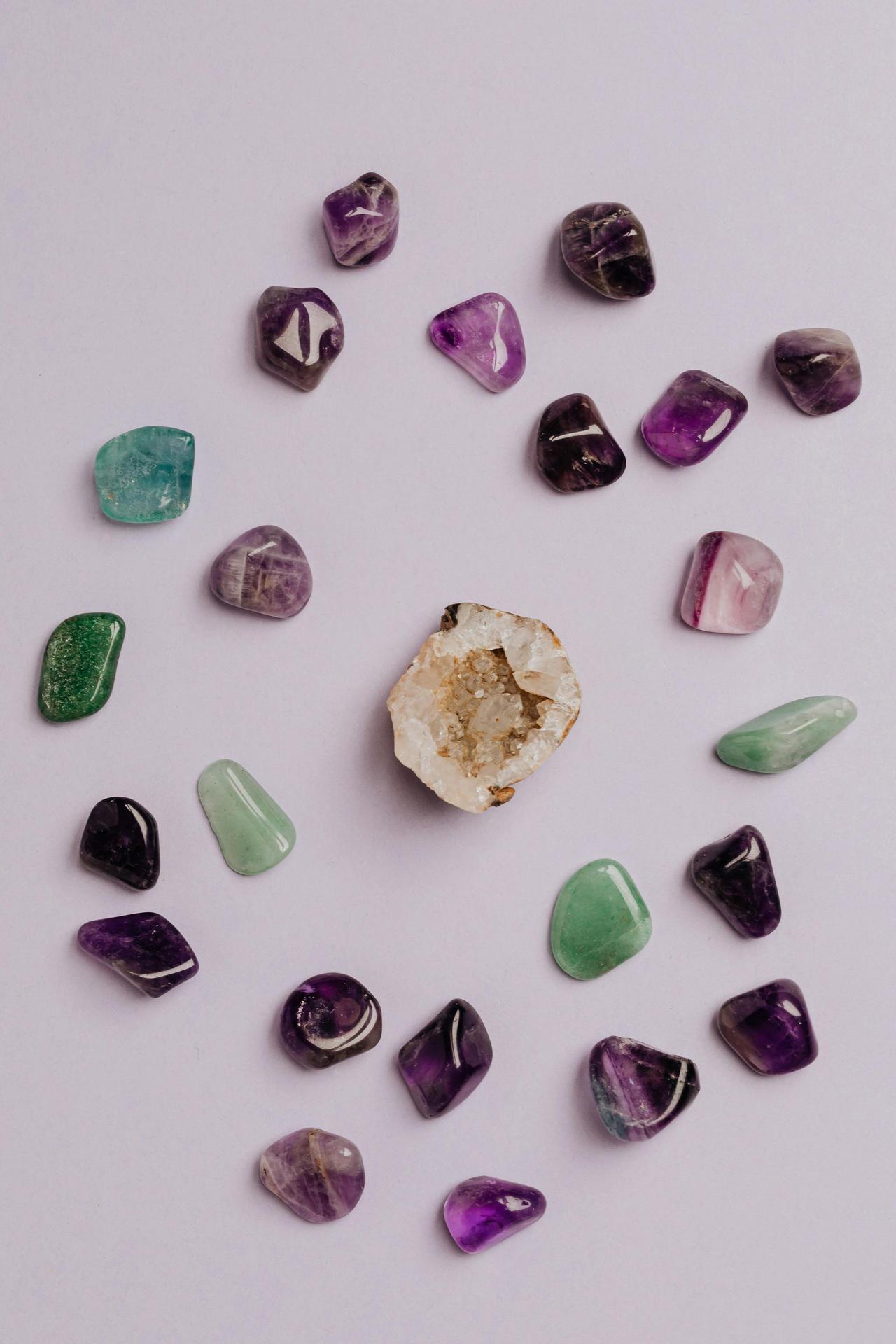 A collection of colorful tumbled gemstones artfully arranged on a neutral background.