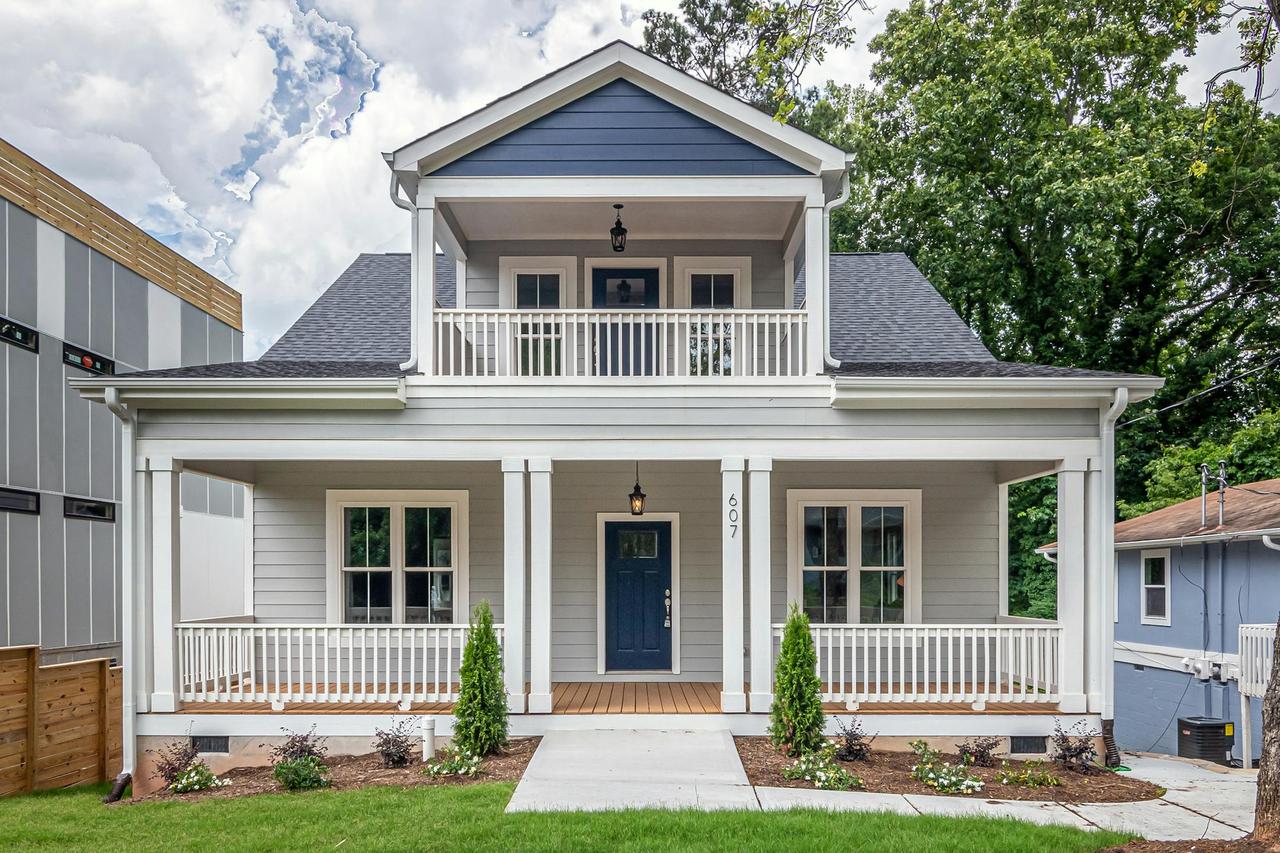 Front view of a modern two-story family home featuring a balcony and spacious porch.
