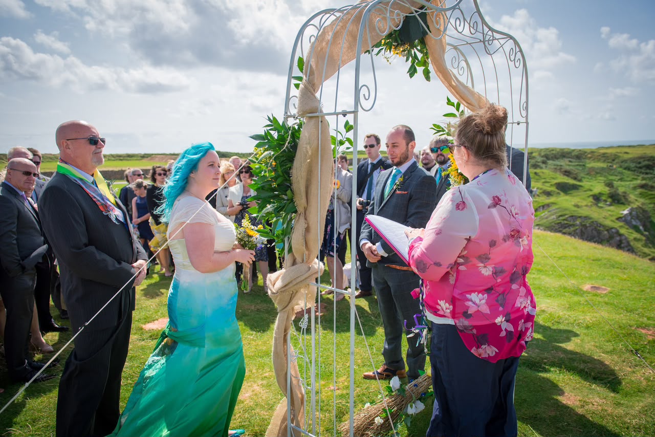 Outdoor wedding ceremony on a hillside with guests