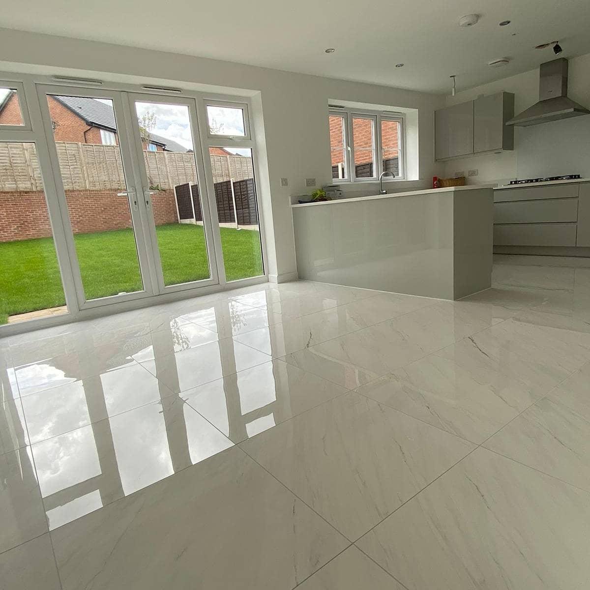 Modern kitchen floor tiling in Coventry with large-format porcelain tiles and flawless reflective finish.
