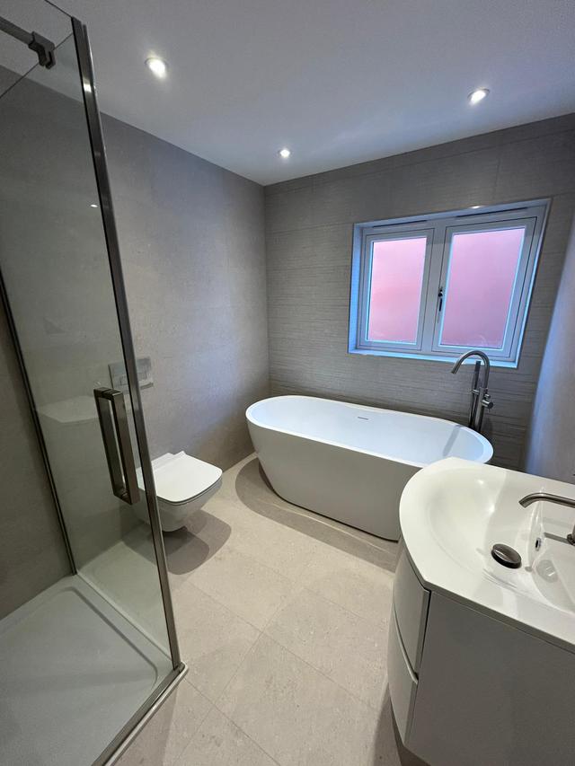 Luxury bathroom tiling in Solihull with walk-in shower, freestanding bath, and full wall tiling