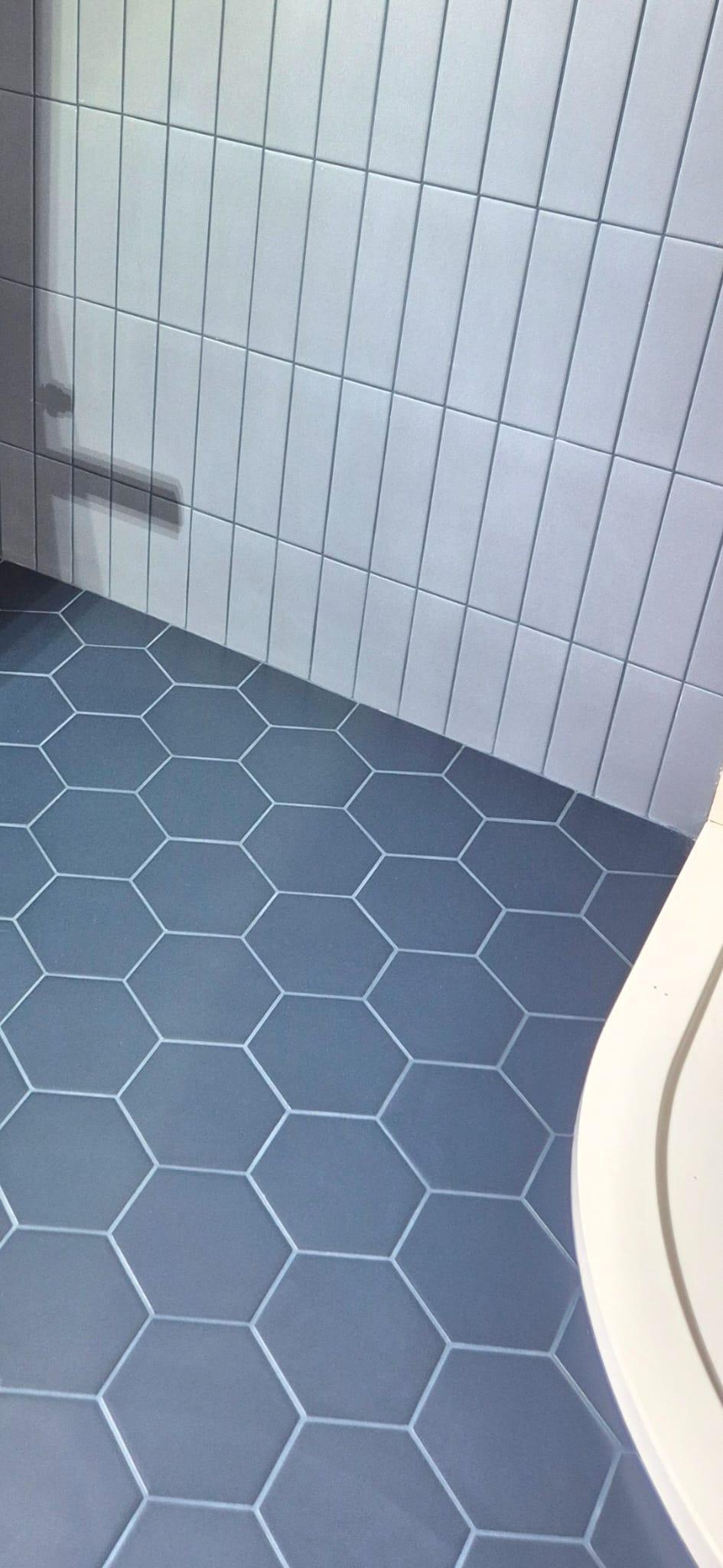 Modern blue tile combination featuring vertical rectangular wall tiles and hexagonal porcelain floor tiles installed by Coventry Tiling