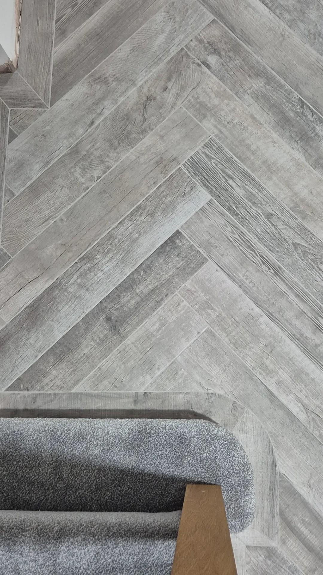Grey herringbone wood-effect tile flooring installed on a staircase by Coventry Tiling