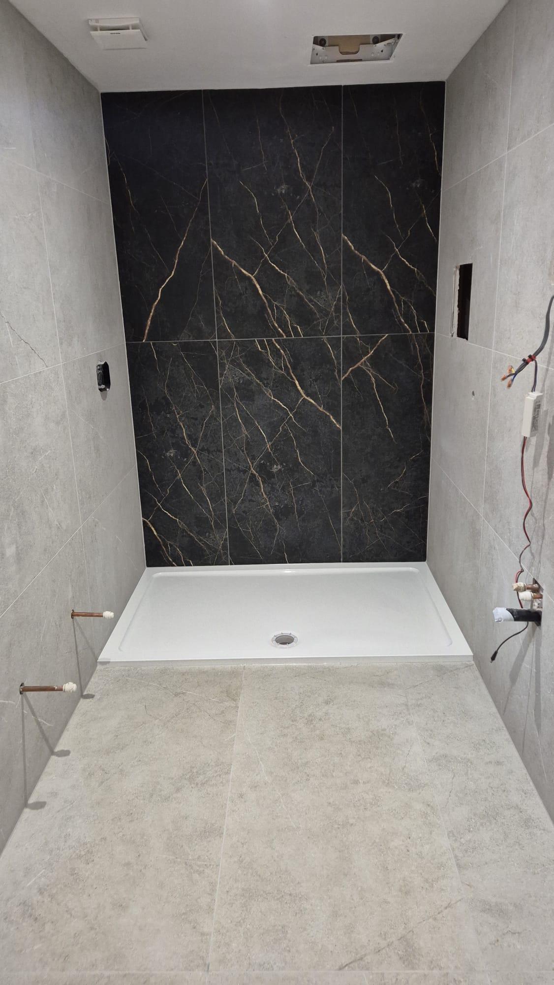 Black marble-effect large format feature tiling above shower tray, Coventry Tiling