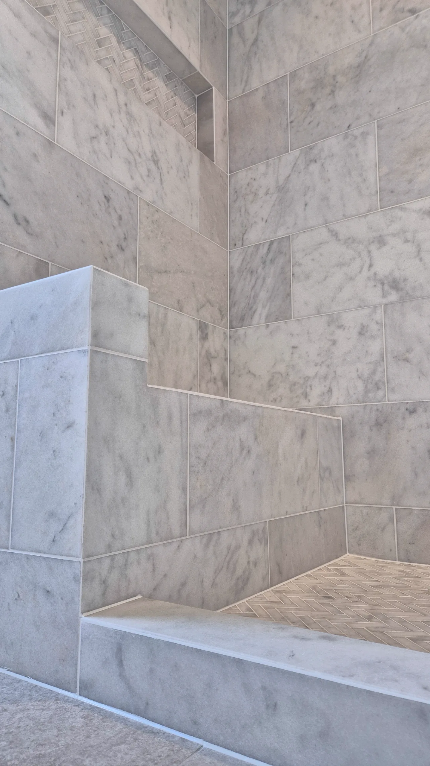 Luxury natural marble wetroom in Kenilworth – epoxy mitred joints, built-in shower seat and tiled niche