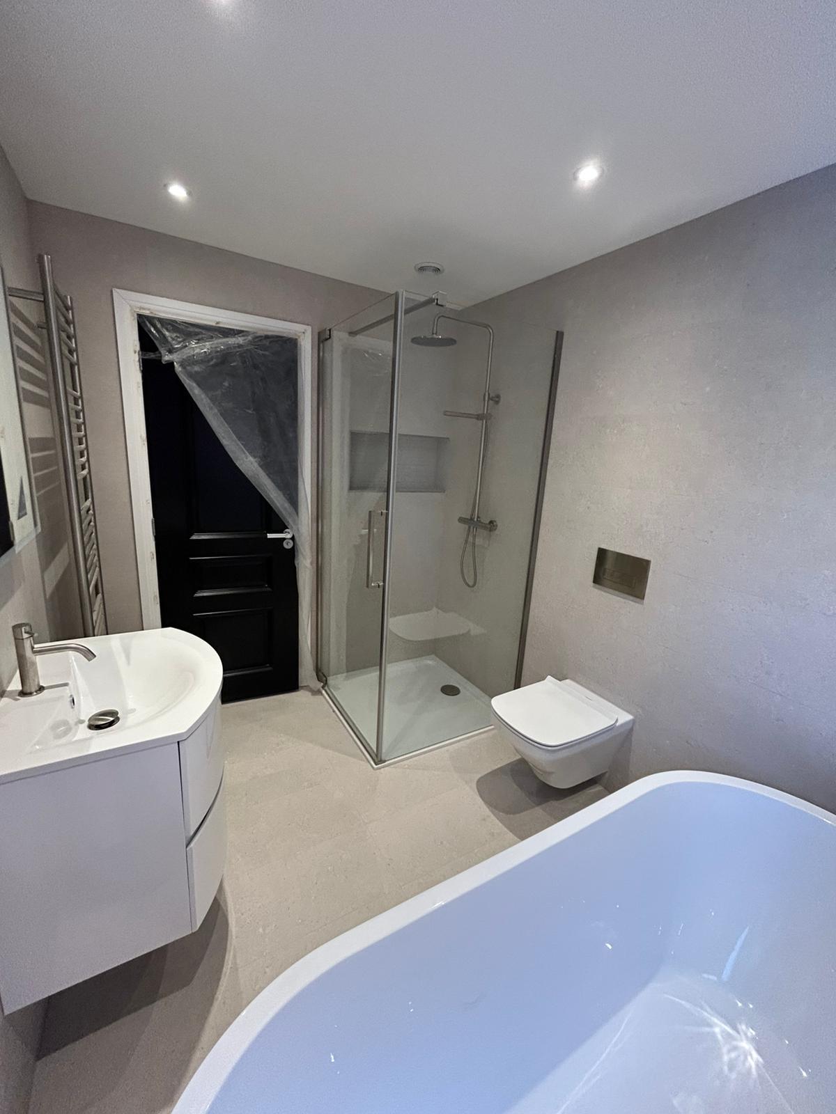 Bathroom installation in Solihull with wall-hung toilet, walk-in shower, and freestanding bath