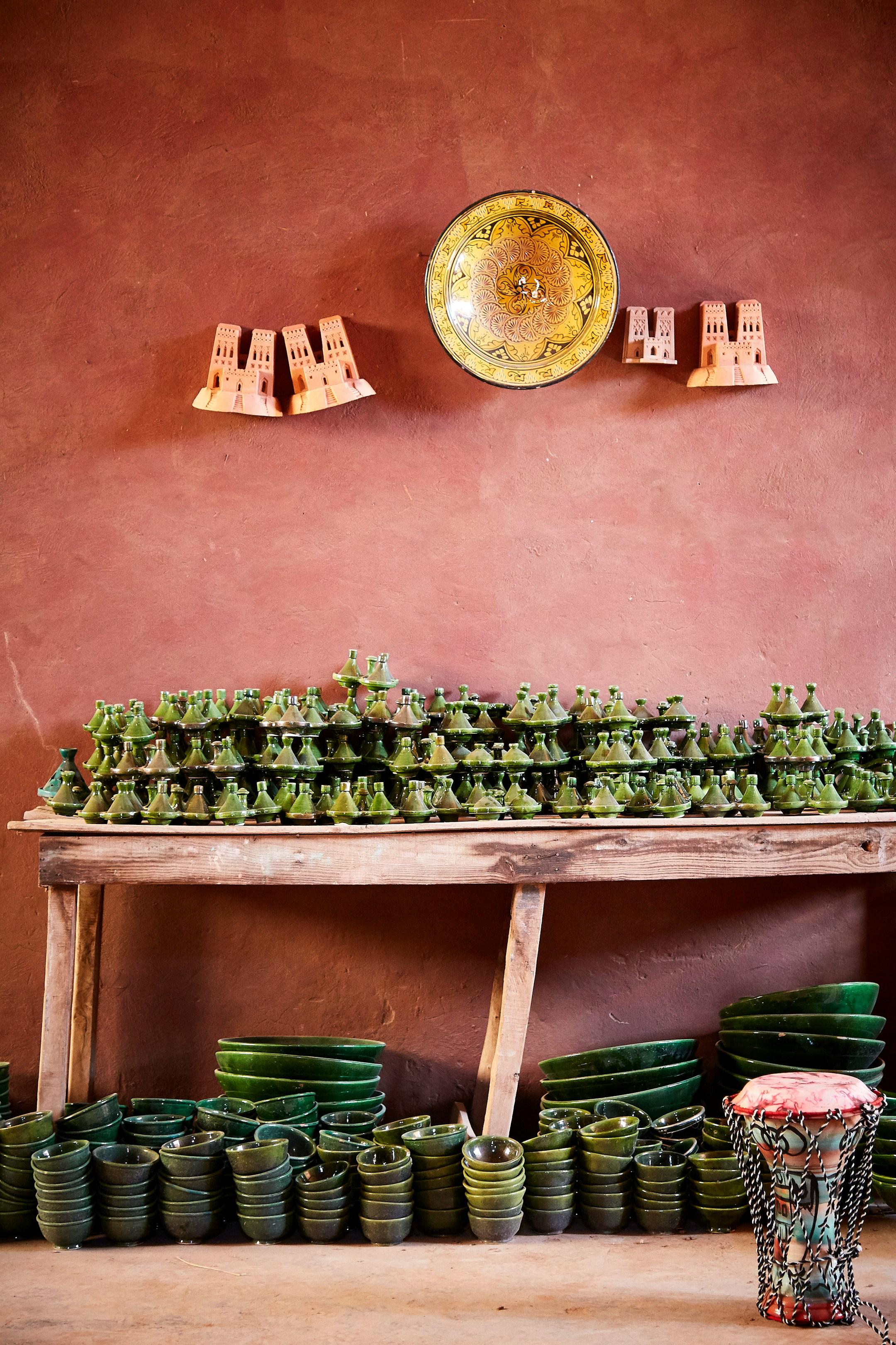 Typical tajine dish exposed into a shop in Zagora, Morocco. I was amazed by the lovely contrast of colors brought by the olive green tajine and the washed red walls.