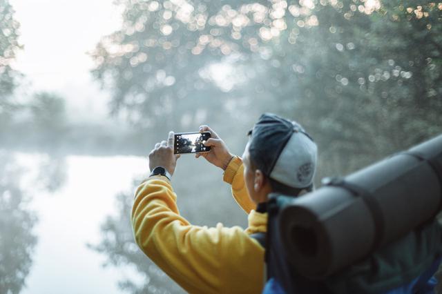 Traveller taking picture of a foggy landscape.