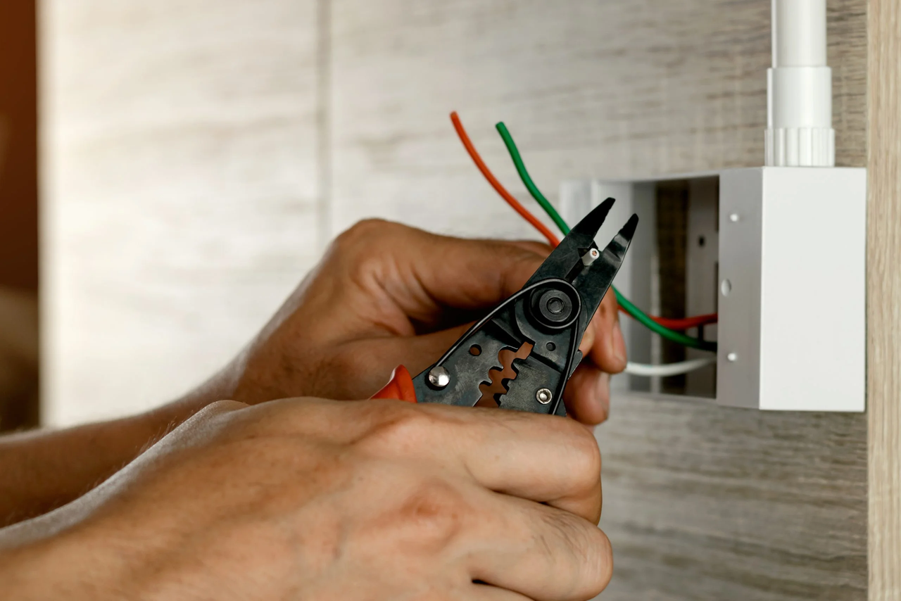39372188_electrician-is-stripping-electrical-wires-in-a-plastic-box-on-a-wooden-wall-to-install-the-electrical-outlet-scaled.jpg.jpg