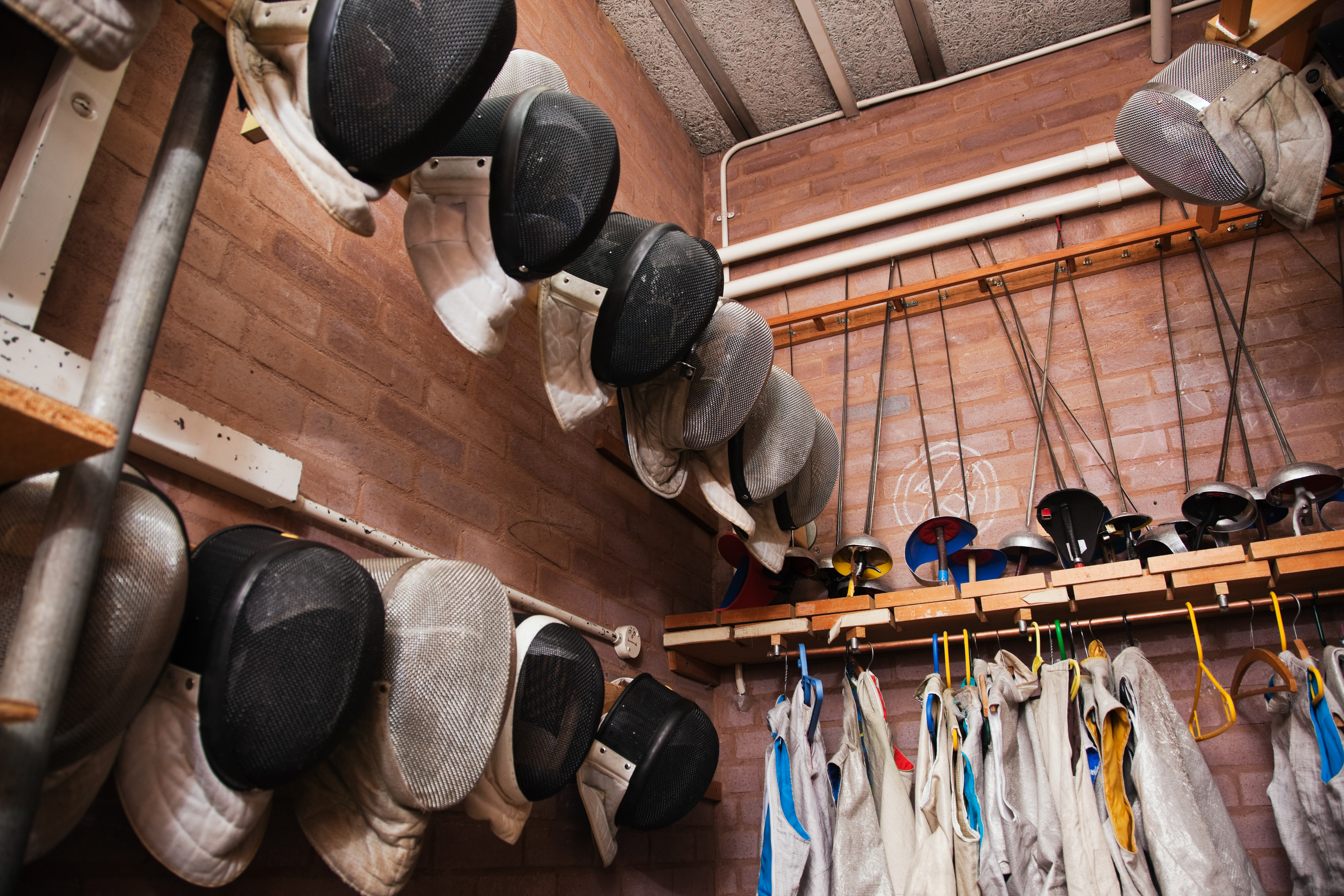 Fencing masks and foils laid out at the club