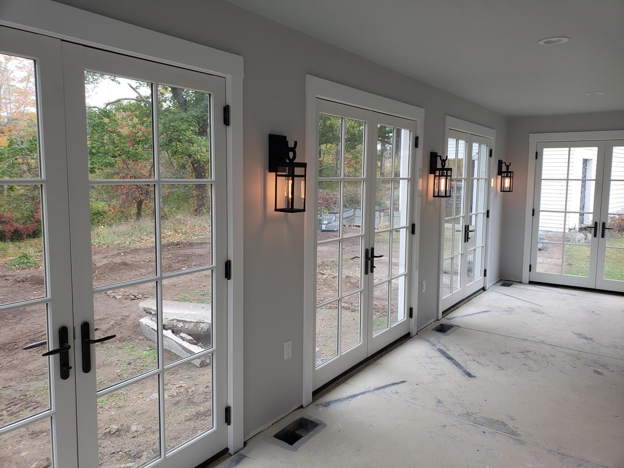 sunroom-with-four-glass-french-doors-and-three-glowing-lanterns-on-the-wall