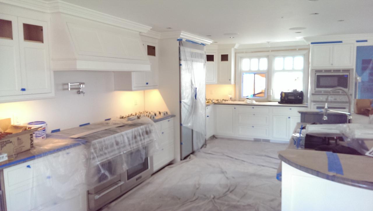 large-open-kitchen-with-cabinets-and-appliances-covered-in-plastic-prepped-and-ready-to-paint