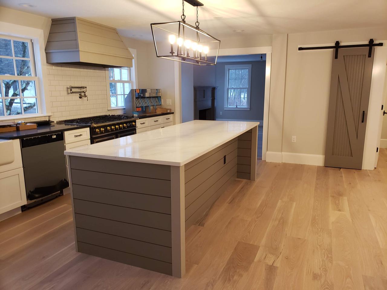 open-kitchen-with-cabinets-chandelier-lighting-and-refinished-wood-island-on-oak-wood-floor