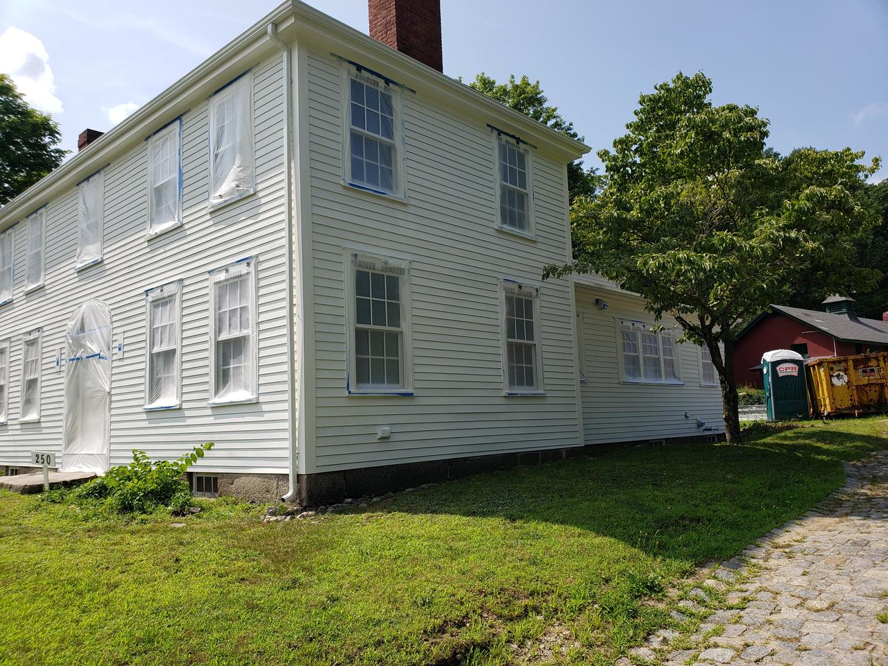 large-white-house-with-plastic-on-windows-primed-and-ready-to-paint